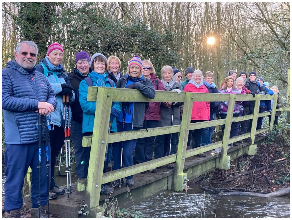 A group of walkers stood on a wooden bridge