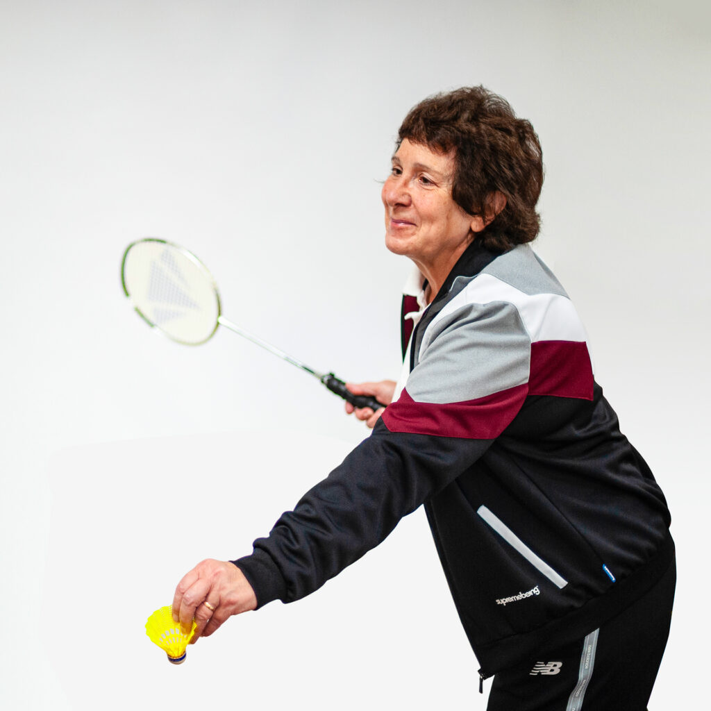 Photo of a woman playing badminton, about to serve