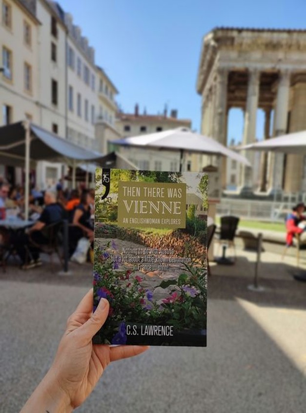 Author holding the book "Then there was Vienne" in a street in Vienne